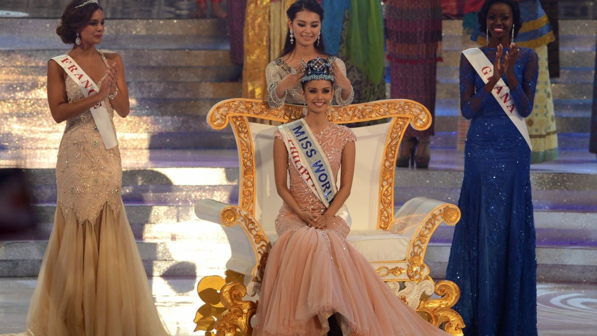„Mis Pasaulis 2012“ Yu Wenxia perduoda savo regalijas naujajai „Mis Pasaulis“ – Filipinų atstovei Megan Young / AFP/„Scanpix“ nuotr.