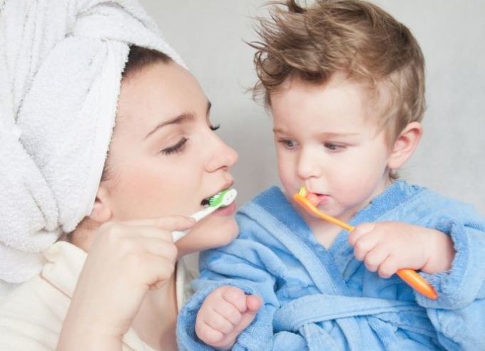 Mama su mažyliu valosi dantukus / Shutterstock nuotr.