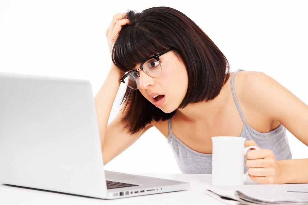 Mergina sėdinti prie kompiuterio ir gerianti kavą / Fotolia nuotr.