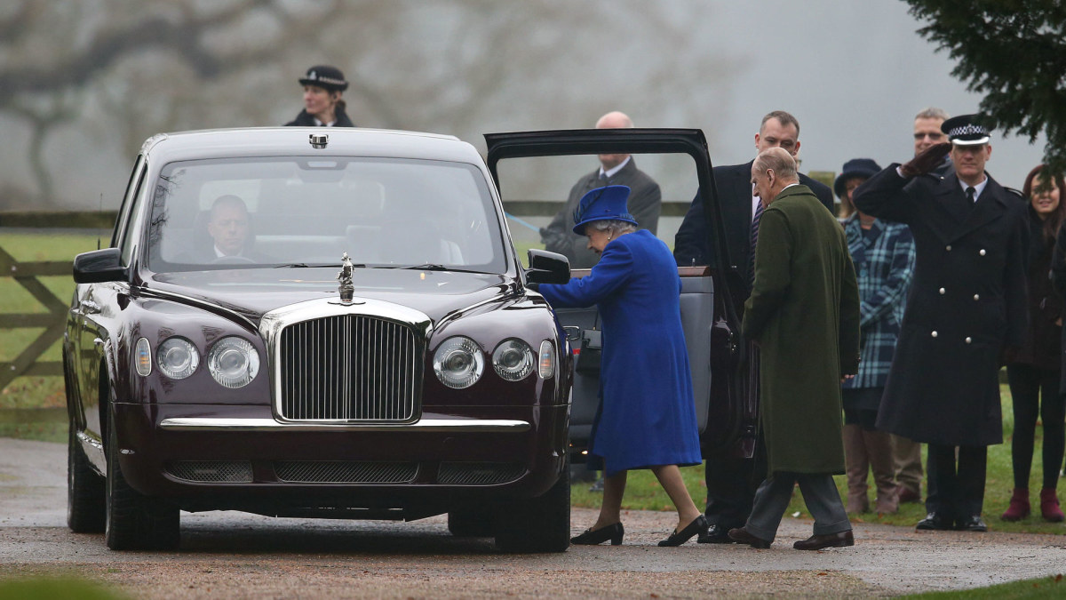 Karalienė Elizabeth II ir princas Philipas lipa į automobilį. / „Scanpix“/„PA Wire“/„Press Association Images“ nuotr.