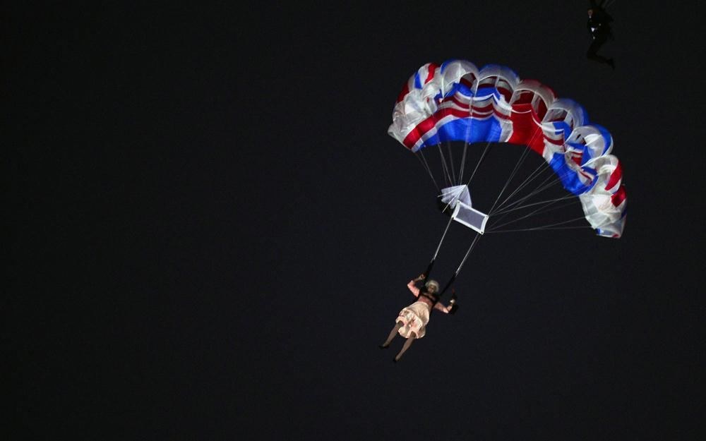 Aktorė persirengusi Didžiosios Britanijos karaliene Elizabeth II iššoko iš sraigtasparnio Londono olimpinių žaidynių atidarymo ceremonijos metu / AFP/„Scanpix“ nuotr.
