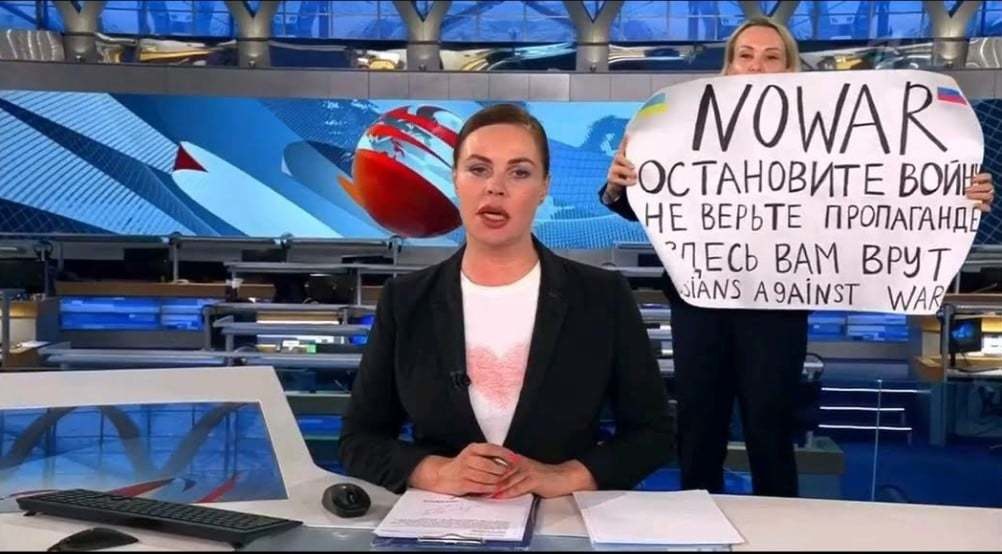 Marina Ovsianikova su plakatu „Karui – ne“ Rusijos vyriausybės griežtai kontroliuojamoje televizijoje „Pervyj kanal“